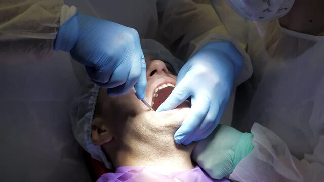 The concept of dental care. Dental treatment in modern dentistry. A close-up shot of a patient in a dental chair undergoing a tooth extraction procedure. Medicine and healthcare. Close-up