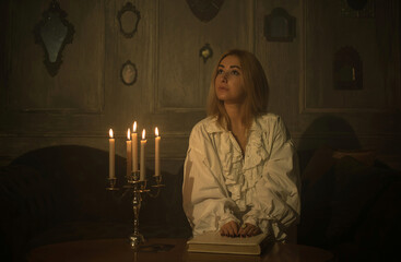 Woman with a candles for fate prediction, details of witch rituals, occultism concept
