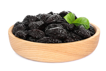 Wooden bowl with sweet dried prunes and green leaves isolated on white