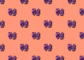 Purple bow for decorating gifts on Calming Coral background. Beautifully tied bow. Photo of a gift package with a seamless pattern.