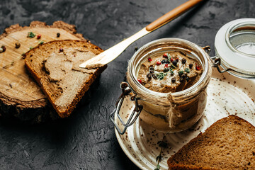 Fresh homemade chicken liver pate in glass jar and baguette slices with pate with herbs. Delicious...