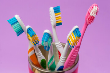 Toothbrushes in a red glass on a purple background. Dental care