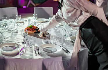 woman hands of a waiter prepare food for a buffet table in a restaurant