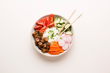 Poke bowl, lunch bowl with fresh vegetables and rice. Asian chopsticks