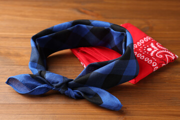 Tied and folded bandanas with different patterns on wooden table