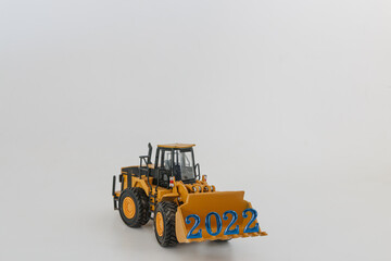 Concept Happy new year 2022,In bucket of Wheel loader   on white background