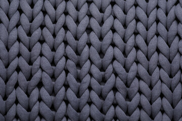 Top view of grey chunky knit blanket as background