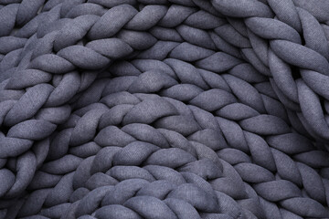 Top view of grey chunky knit blanket as background