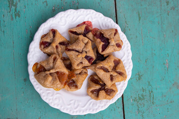 Czech cheesecake pastry folded cubes baskets biscuits wrapped filled with red jam on rustic scratched vintage background