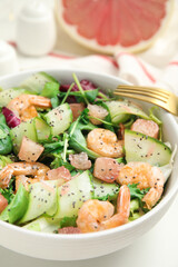 Delicious pomelo salad with shrimps served on white  table, closeup