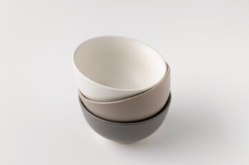 ceramic crockery, bowls stacked in a stack, on a white background, close up