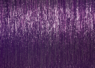 Festive background. Purple foil decor, tinsel. Festive and cheerful mood.