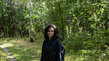 Woman with black sweat smiling in the forest