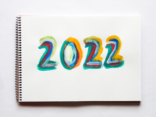 スケッチブックの白い画用紙に水彩絵の具でラフに描いた２０２２。真上からの撮影。