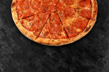 Tasty pizza on black concrete background. Top view of hot pizza. With copy space for text. Flat lay. Banner.