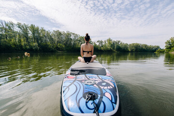 a beautiful girl in a swimsuit is sitting on a board