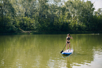 Fototapeta na wymiar a beautiful girl in a swimsuit is standing on a board