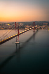 Sunset view over capital of Portugal  Lisbon. The most iconic landmark is the subject of this picture the Ponte 25 de Abril. © Glenn