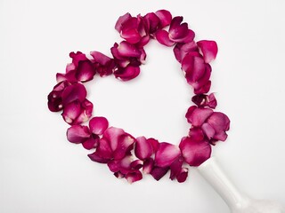 Obraz premium Heart-shaped rose petals spilled from a fallen vase, Valentines card