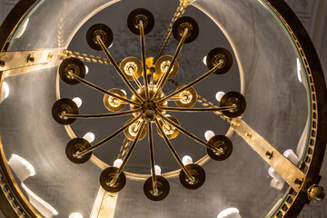 vintage chandelier made of metal and glass under the ceiling close-up 