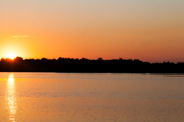 lake during sunset with yellow-orange sky