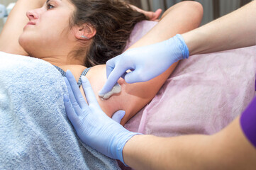 Obraz na płótnie Canvas Hair removal armpit with sugar paste in a beauty salon