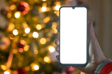 Cropped of woman's hands holding smartphone at Christmas time