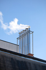 Natural gas exhaust floating above the chimneys of an apartment building, greenhouse gases. 