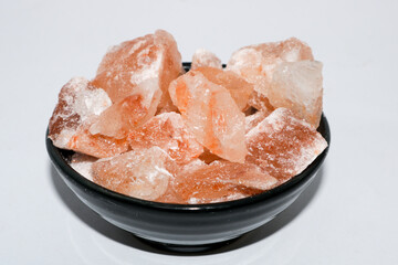 Close up shot of pink himalayan salt blocks in black bowl.