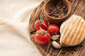 chicken with vegetables on a wooden board. meat with tomatoes and spices