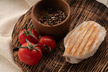chicken with vegetables on a wooden board. meat with tomatoes and spices
