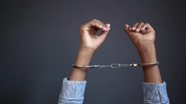man's hand with handcuff on black background.