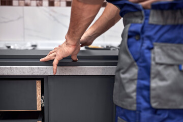 Handyman making kitchen wall cabinets in the apartment.