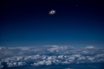 Fototapeta na wymiar Solar eclipse on a dark blue sky above clouds and atmosphere.