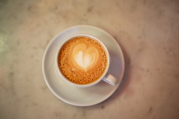 Coffee cup with cappuccino on old marble background. Soft focus shallow DOF vintage style  picture