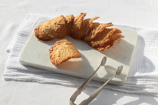 Almond Tiles cookies placed on plate on tablecloth