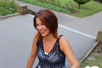 Portrait young woman sitting on a bench laughing with best friend outdoor park.
