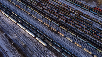 Air view view of different railway wagons and tanks on an industrial railroad during the winter.  - obrazy, fototapety, plakaty