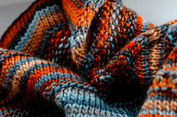 fragment of warm striped sweater, close-up. Hygge cozy atmosphere of craft. Soft focus
