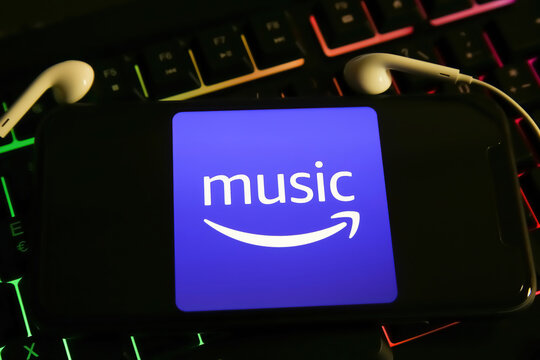 Viersen, Germany - May 9. 2021: Closeup of smartphone screen with logo lettering of amazon music online music streaming service  on computer keyboard