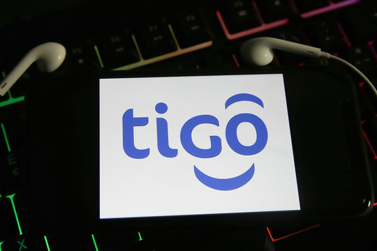 Viersen, Germany - May 9. 2021: Closeup of smartphone screen with logo lettering of tigo online music streaming service  on computer keyboard