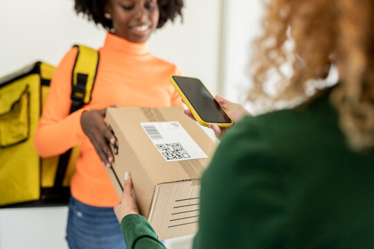 Black woman courier delivering parcel of internet order