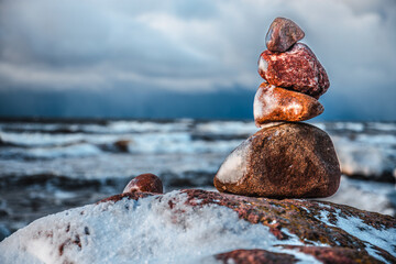 Sunlight shines on the sea waves. The wind blows the waves ashore. In winter, the embankment is icy...