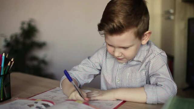 Russian boy does his homework. First grader