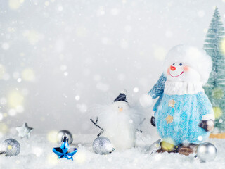Snowman, balloons, stars in the snow on a white background with bokeh.