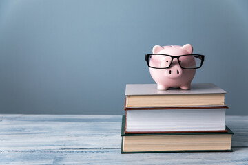 piigy bank with glasses on books