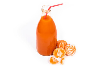 white background. a glass bottle with an orange liquid in it. juice of tangerine, and carrots, as...