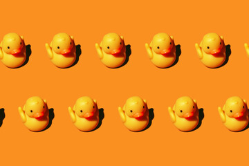 Seamless pattern: yellow rubber toy duck isolated on bight orange background