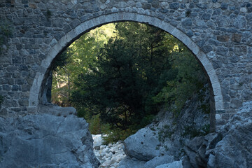 arch of ancient Roman bridge over a mountain river in the Kesme Bogazi canyon, Turkey