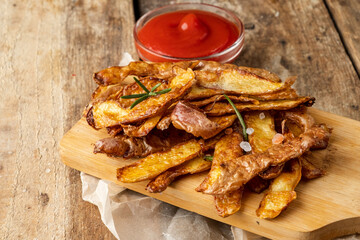 Crispy potato peel chips served on a wooden board.